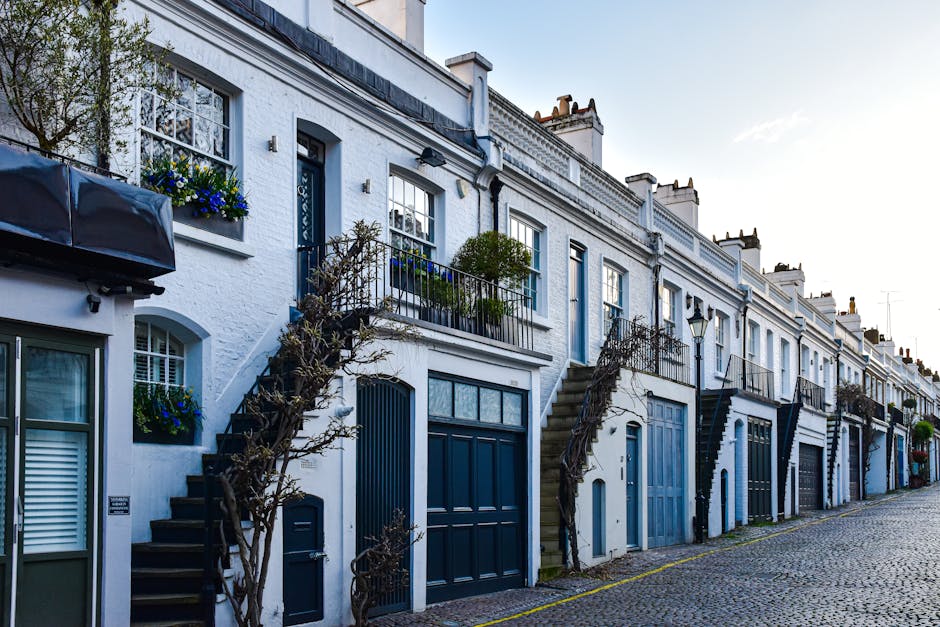 A row of Victorian-style terraced residential buildings with red brick facades and white decorative architectural details including ornate window frames, cornices, and columns. The buildings feature t